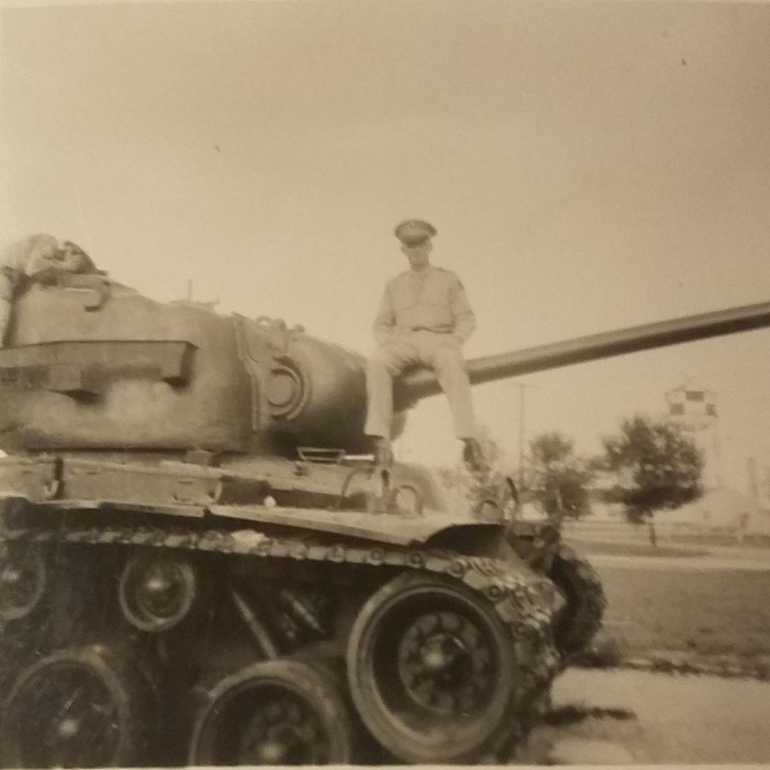 Stan sitting on a tanks gun